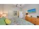 Comfortable bedroom with a TV above a wooden dresser and brightly colored bedding with matching throw pillows at 2047 Roselawn St, Sarasota, FL 34231