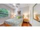 Cozy bedroom featuring hardwood floors, ceiling fan and bright natural light at 2047 Roselawn St, Sarasota, FL 34231