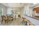 A dining area with chandelier lighting and a view into the kitchen is connected to a living area at 2047 Roselawn St, Sarasota, FL 34231