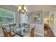 The dining area showcases a glass table set for dinner under the light of a charming chandelier at 2047 Roselawn St, Sarasota, FL 34231