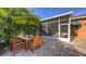 Outdoor patio with wood table and chairs and a screened-in patio behind at 2047 Roselawn St, Sarasota, FL 34231