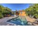 Relaxing exterior living with a pool, screened lanai, and an outdoor dining area with lush landscaping at 2047 Roselawn St, Sarasota, FL 34231