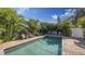 Private backyard pool features a surrounding brick patio and lush tropical landscaping for ultimate relaxation at 2047 Roselawn St, Sarasota, FL 34231