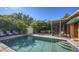 The pool is surrounded by a brick paver patio and a tall privacy hedge at 2047 Roselawn St, Sarasota, FL 34231