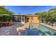 Exterior pool view showing screened lanai, outdoor dining and exterior elevation with mature landscaping at 2047 Roselawn St, Sarasota, FL 34231