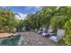 Tranquil poolside lounge area with multiple chairs and lush tropical landscaping creating a private retreat at 2047 Roselawn St, Sarasota, FL 34231