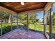 This is a view of the tiled flooring, wood ceiling, and open-air feel of this home's screened-in porch at 2186 Arlington St, Sarasota, FL 34239