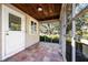 Open-air screened porch with tiled floors, wood ceiling, and access door at 2186 Arlington St, Sarasota, FL 34239