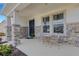 Charming front porch with stone accents and a cozy seating area for relaxing outdoors at 2208 Midnight Pearl Dr, Sarasota, FL 34240