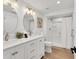 Bright bathroom with double sinks, white cabinets, and a shower at 310 Magnolia Ave, Anna Maria, FL 34216