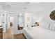 Bright bedroom with white walls, ceiling fan, and view into bathroom and hallway at 310 Magnolia Ave, Anna Maria, FL 34216