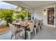 An outdoor dining area with seating for eight offers a tropical view at 310 Magnolia Ave, Anna Maria, FL 34216