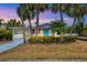 Charming home with manicured landscaping, a bright blue front door, and a cozy screened-in porch, perfect for enjoying the coastal lifestyle at 310 Magnolia Ave, Anna Maria, FL 34216
