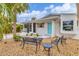 Well-kept home exterior featuring a quaint seating area and a bright blue front door at 310 Magnolia Ave, Anna Maria, FL 34216