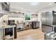 Modern kitchen with stainless steel appliances, open shelving, and white subway tile backsplash at 310 Magnolia Ave, Anna Maria, FL 34216