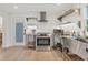 Contemporary kitchen featuring stainless steel appliances, open shelving, and ample counter space at 310 Magnolia Ave, Anna Maria, FL 34216