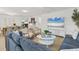 Comfortable open-concept living area with modern furnishings, a large TV, and dining space at 310 Magnolia Ave, Anna Maria, FL 34216