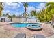 A private backyard features a kidney shaped pool with a separate hot tub, surrounded by tropical landscaping and lounge chairs at 310 Magnolia Ave, Anna Maria, FL 34216