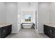 Bright bathroom featuring a soaking tub, marble accents, and dual vanities at 3188 Tropicaire Blvd, North Port, FL 34286