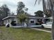 A cozy grey single-story home featuring small palm trees and a well-kept lawn at 3305 13Th W Ave, Bradenton, FL 34205