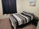 Comfortable bedroom featuring striped bedding, dark curtains, and a nightstand at 3528 Lake Bayshore Dr # K-115, Bradenton, FL 34205