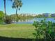 Picturesque lake view with lush green lawn and the building's facade across the calm waters on a clear day at 3528 Lake Bayshore Dr # K-115, Bradenton, FL 34205