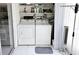 Functional laundry area with washer, dryer, shelving, and essential cleaning supplies at 3528 Lake Bayshore Dr # K-115, Bradenton, FL 34205