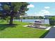 Outdoor picnic area featuring a grill, picnic table, lush green grass, and a serene waterfront view at 3528 Lake Bayshore Dr # K-115, Bradenton, FL 34205