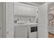 Bright laundry room with white washer and dryer, upper cabinets and folding doors at 3850 Mariners Walk # 713, Cortez, FL 34215