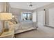Inviting main bedroom with plush carpet, four-poster bed, and a serene view from the sliding glass door at 3850 Mariners Walk # 713, Cortez, FL 34215