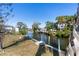 Lush backyard view of a serene canal and private boat docks, perfect for waterfront living and outdoor enjoyment at 400 Dona Dr, Nokomis, FL 34275