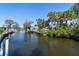 Scenic canal view surrounded by lush greenery and boats docked at waterside properties under a clear blue sky at 400 Dona Dr, Nokomis, FL 34275