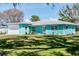 Charming turquoise home with a well-manicured lawn on a sunny day at 400 Dona Dr, Nokomis, FL 34275