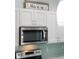 White kitchen cabinets with clear pulls, stainless steel appliances and mosaic backsplash at 400 Dona Dr, Nokomis, FL 34275