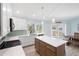 Bright kitchen boasts white cabinets, an island and stainless steel appliances at 400 Dona Dr, Nokomis, FL 34275