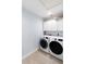 Well lit laundry room with cabinets and front loading washer and dryer at 400 Dona Dr, Nokomis, FL 34275