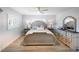 Bright main bedroom featuring wood floors, ceiling fan, and matching bedside tables and dresser at 400 Dona Dr, Nokomis, FL 34275