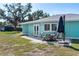 Charming outdoor patio with dining set, grill, and umbrella, perfect for al fresco dining and entertaining at 400 Dona Dr, Nokomis, FL 34275