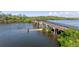 Elevated view of long pier over water with green foliage in the background at 400 Dona Dr, Nokomis, FL 34275