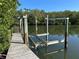 Wooden dock features a boat lift and picturesque views of the serene waterway at 4207 Marina View Way, Cortez, FL 34215