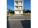 Three-story beige home with garage, multiple balconies and manicured landscaping at 4207 Marina View Way, Cortez, FL 34215