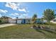 Well-manicured front yard with lush green grass and lovely landscaping enhances this blue home's curb appeal at 45 Englewood Heights Rd, Englewood, FL 34223