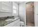 Well-lit bathroom featuring granite countertop vanity and walk-in shower with floor to ceiling tile at 5120 Beacon Rd, Palmetto, FL 34221