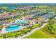 Aerial view of resort-style amenities including a pool, tennis courts, and clubhouse surrounded by lush greenery at 5529 Mulligan Way, Bradenton, FL 34211