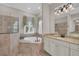Bright bathroom featuring dual vanity sinks, tiled shower, and a corner tub by a window at 5529 Mulligan Way, Bradenton, FL 34211