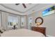 Bright bedroom featuring a ceiling fan, TV, natural light, and a decorative mirror and dresser at 5529 Mulligan Way, Bradenton, FL 34211