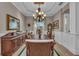 Formal dining room featuring wainscoting, a chandelier, and light wood floors at 5529 Mulligan Way, Bradenton, FL 34211