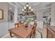 Elegant dining room with chandelier, wainscoting, and a view into the living area at 5529 Mulligan Way, Bradenton, FL 34211