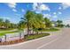 A stone entrance to a community with gorgeous mature landscaping, palm trees and annual flowers at 5529 Mulligan Way, Bradenton, FL 34211