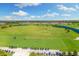 Scenic aerial view of golfers on the lush green golf course in a beautiful community on a sunny day with a pond in the distance at 5529 Mulligan Way, Bradenton, FL 34211